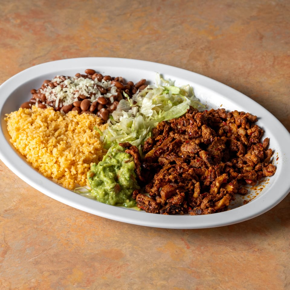 Individual seasoned meat plate with rice and beans.