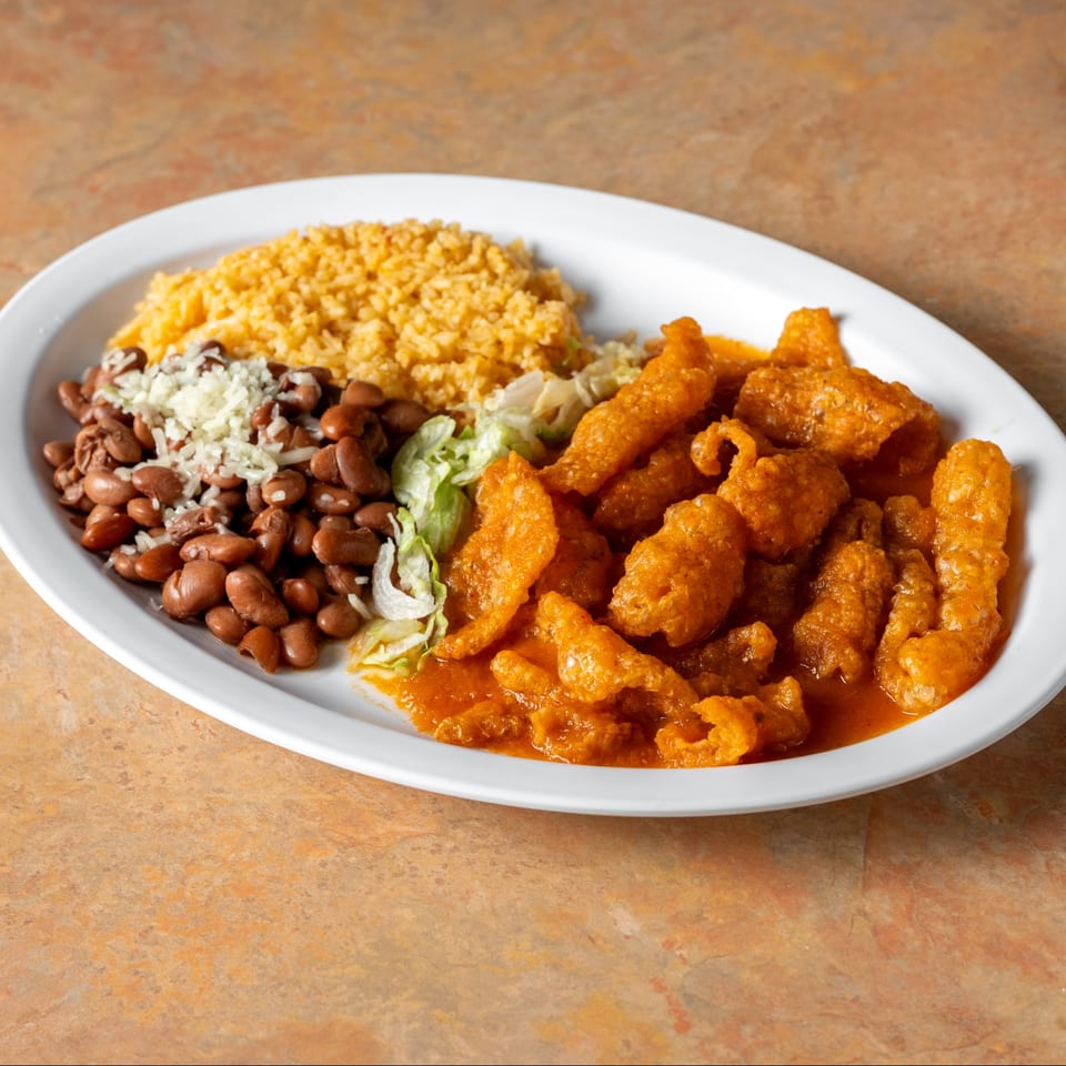 Meat in red sauce with rice and beans.
